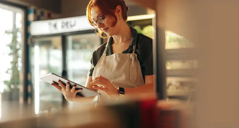 Grocery store owner holding a tablet