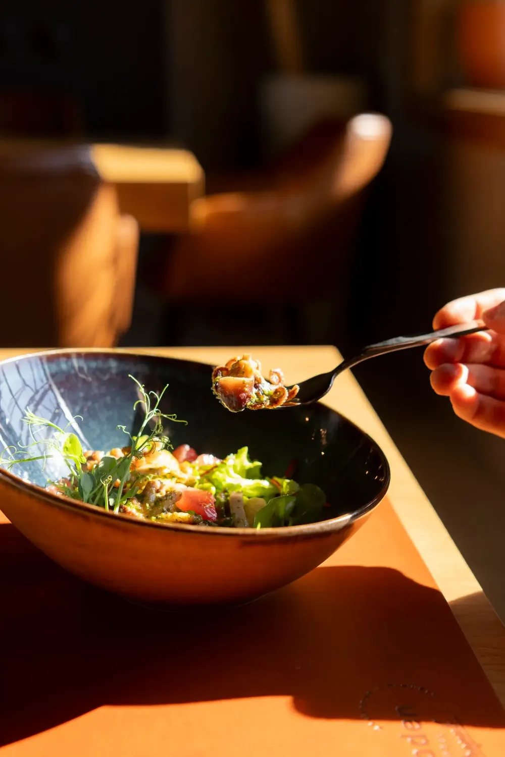 A person using a fork to taste a delicious seafood dish