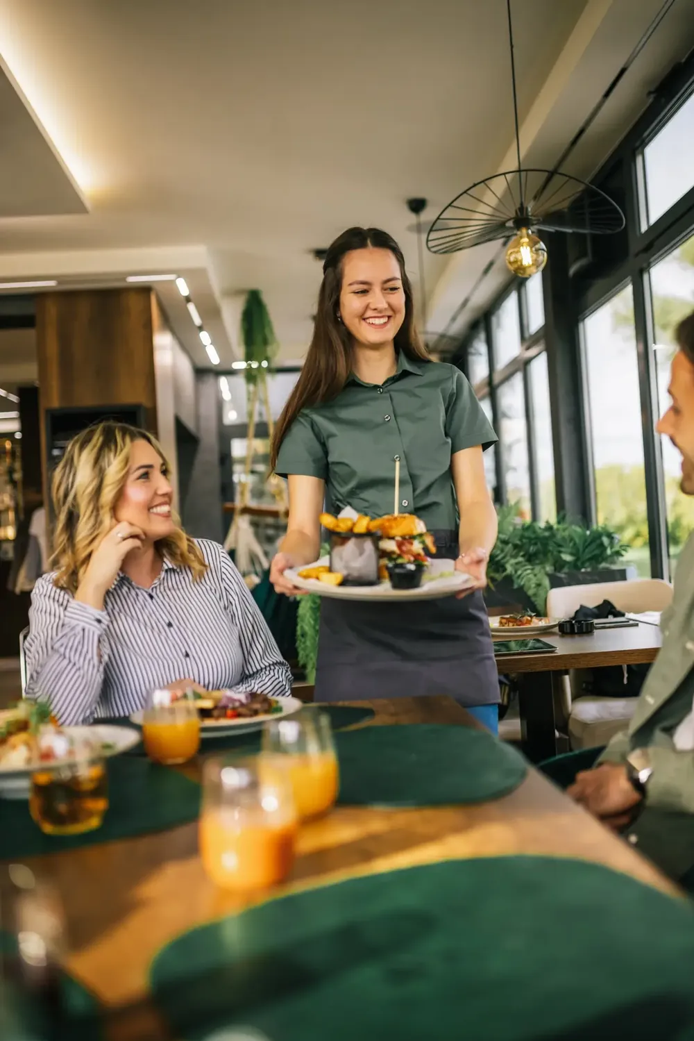 A waitress happily serving a customer their food